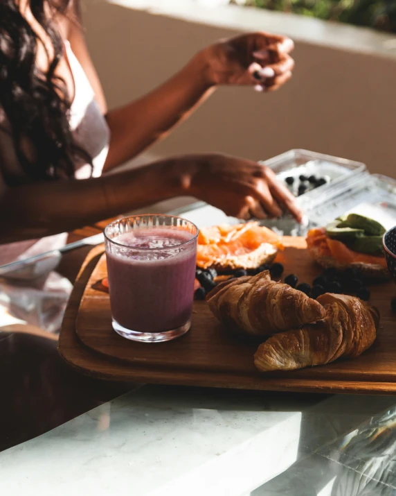 woman at dinner with fruit, croissant and juice