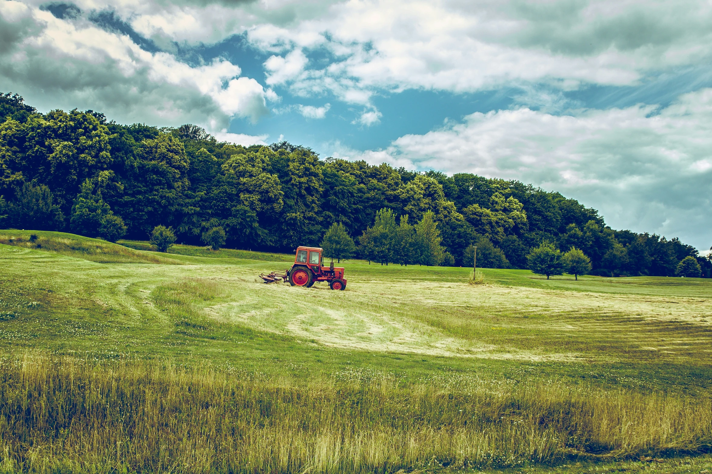 a tractor working in a field with mountains in the background