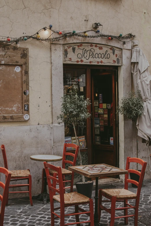 the exterior of a coffee shop with lots of chairs and tables