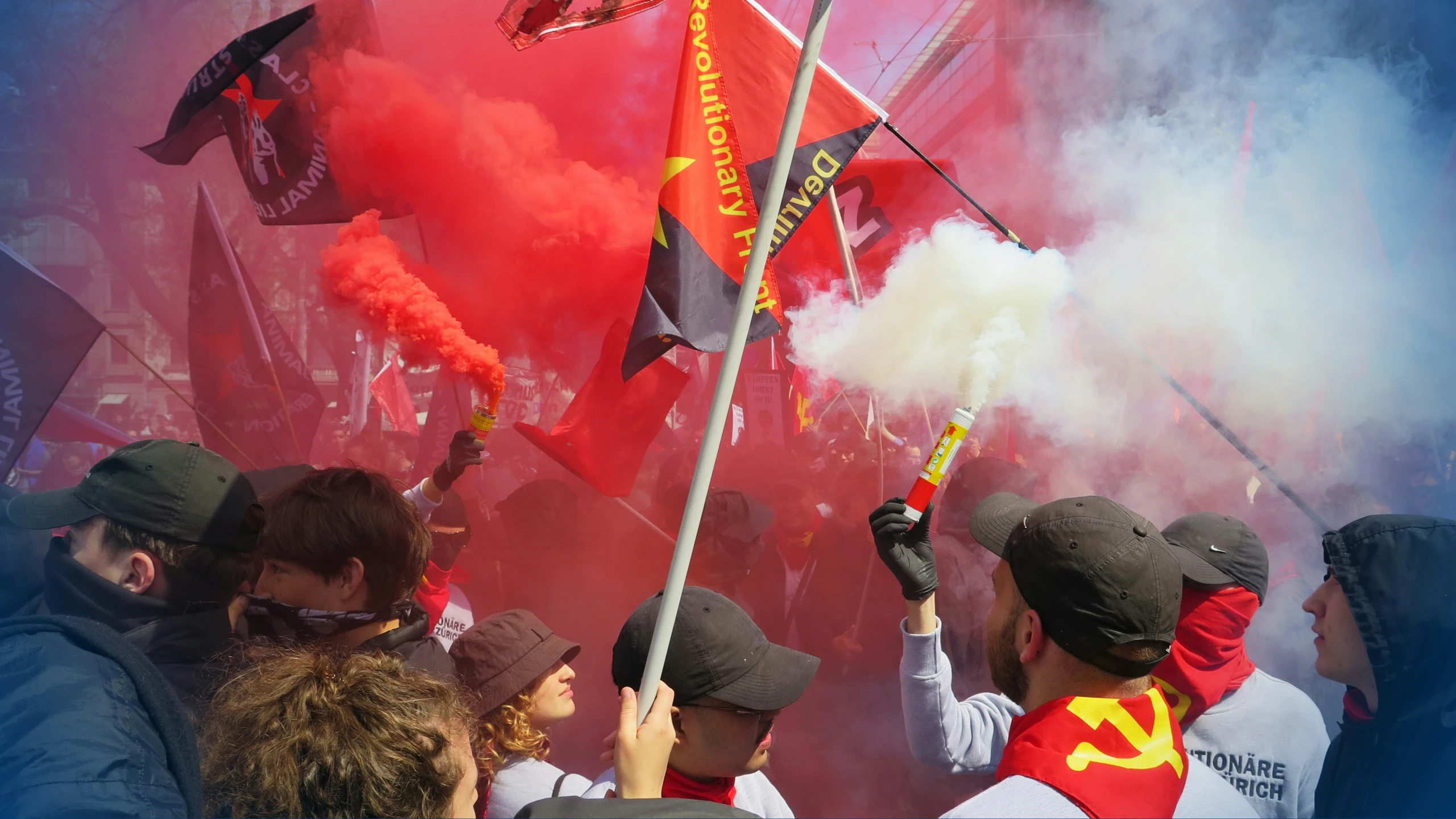 group of soccer fans blowing smoke and flags