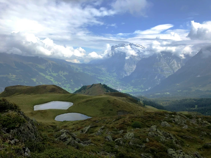 a view of some mountains and clouds over the lake