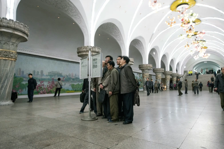 a group of men that are standing in the hallway