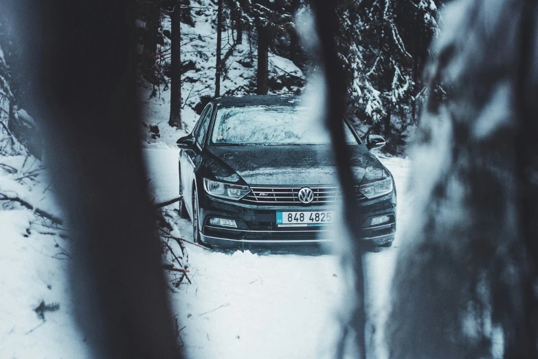 the car is parked on the snow covered road