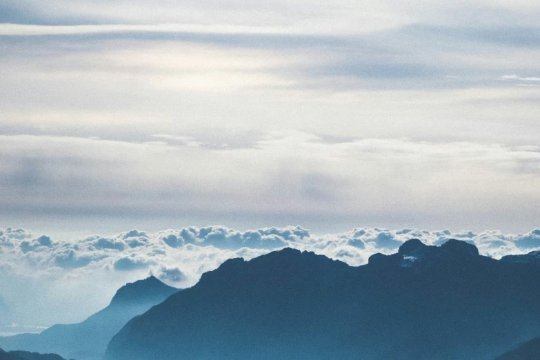 the sky with clouds in the mountains in the distance