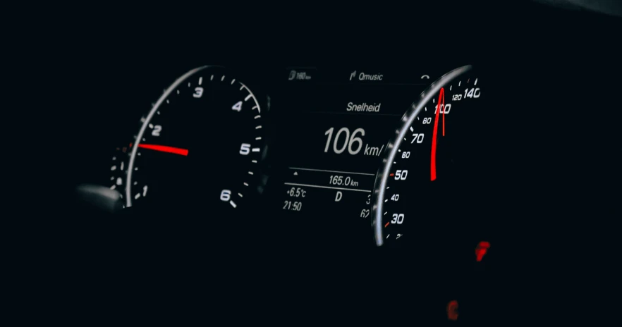 the dashboard and dash lights of a car in a dark room