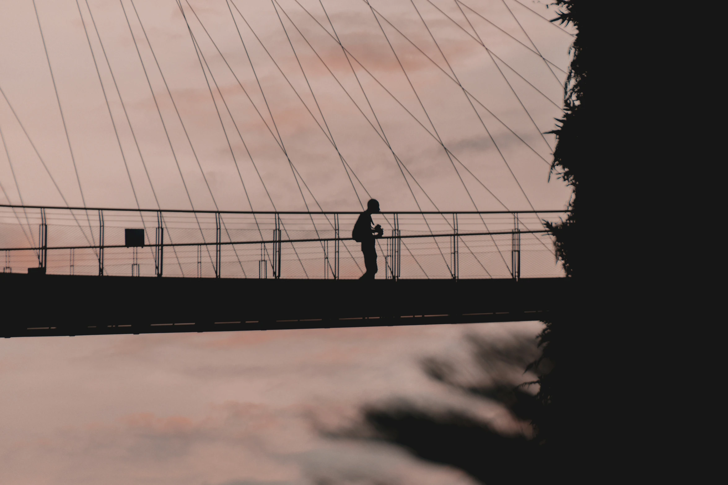 a person walking across a bridge that has string attached to it