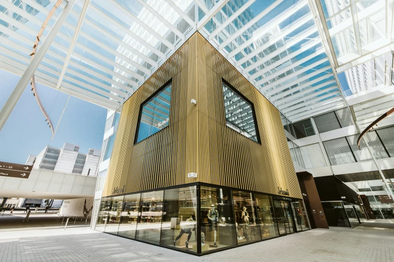 large open air lobby with high ceilings and a triangular shaped glass entrance