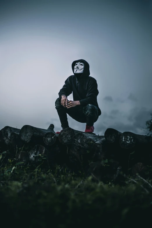 the man is crouched on some large rocks