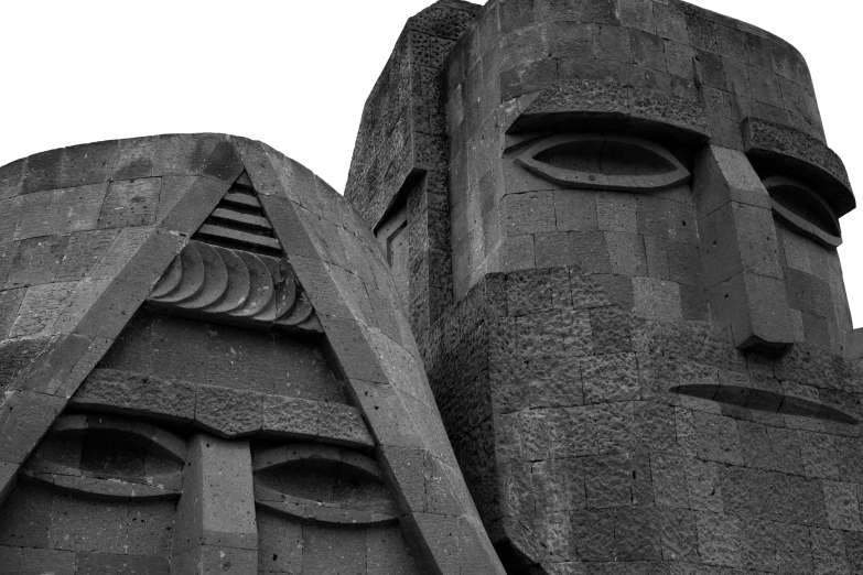 black and white pograph of faces on the outside of a castle