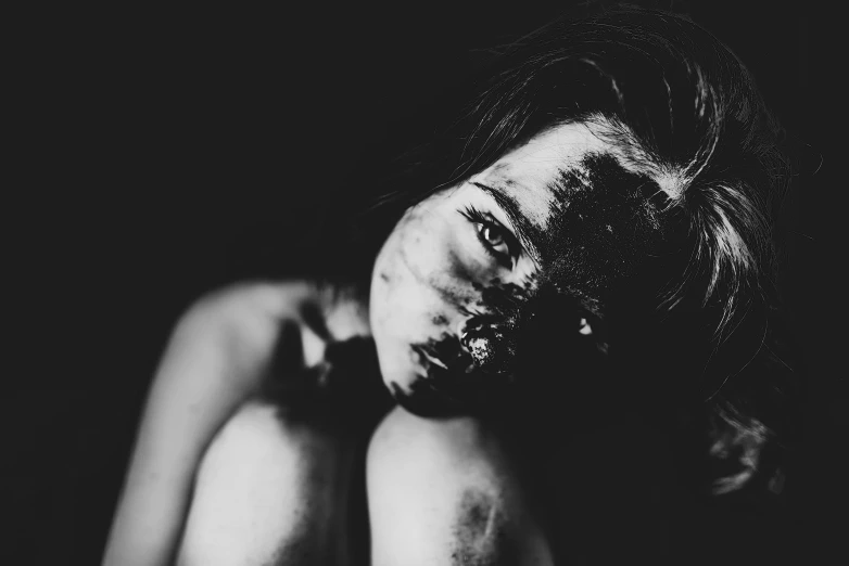 a woman's face covered with makeup in black and white