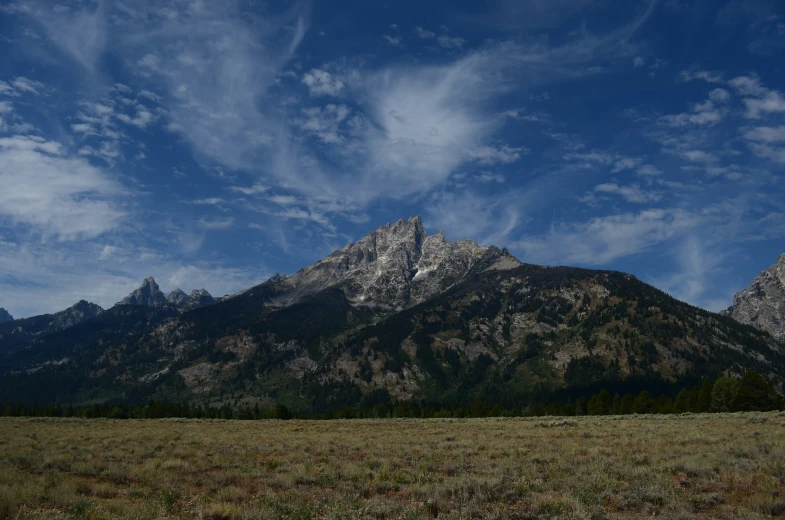 a landscape image of some mountains under the cloudy sky