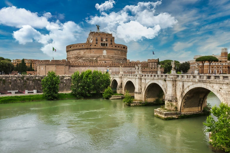 bridge over the water leading to a castle on a hill