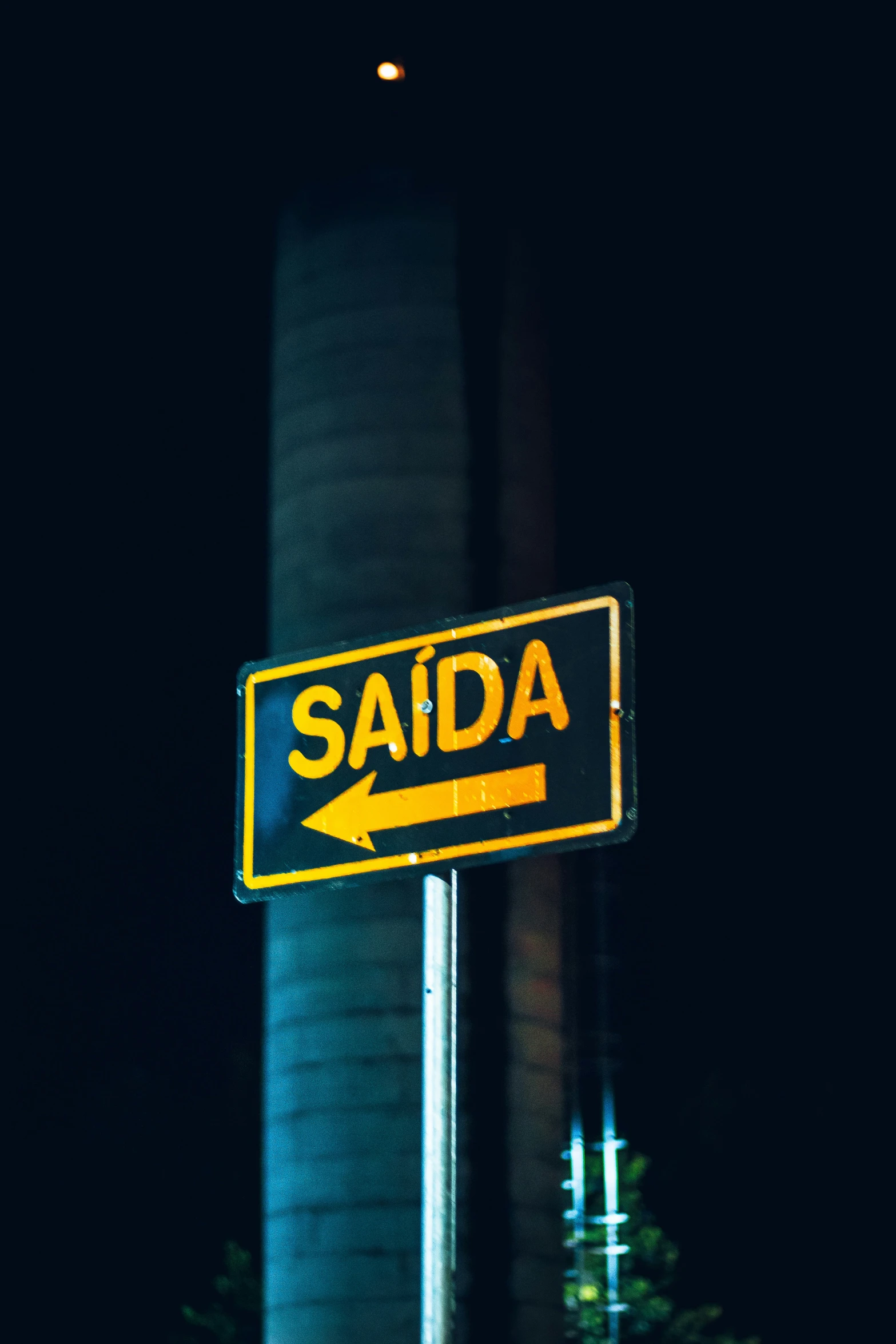 a yellow street sign is in front of a black building