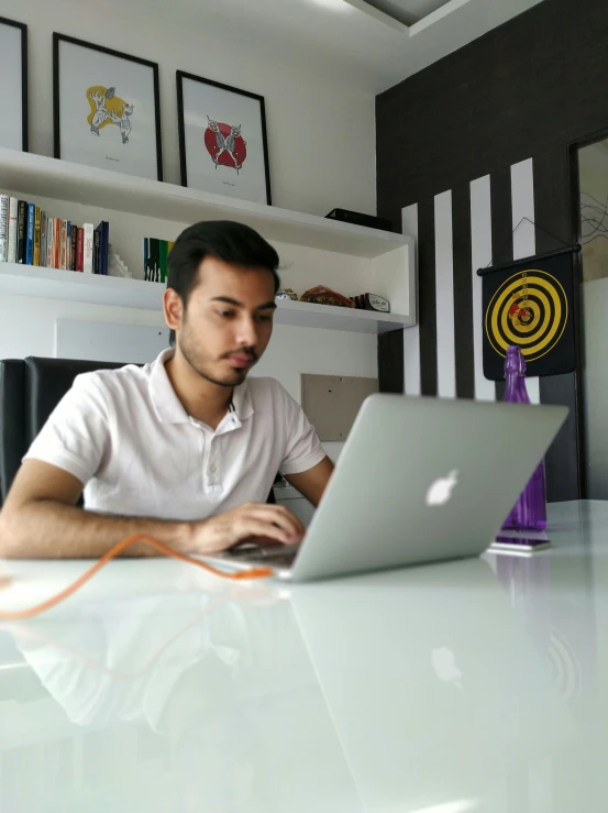 the man is working on his laptop at a desk