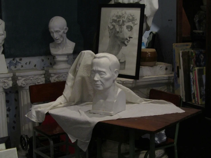 a bust of a man next to some statues of other heads