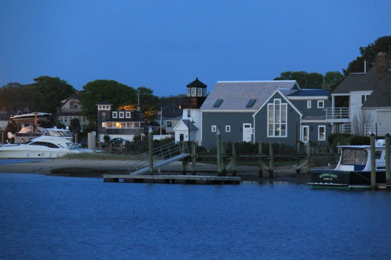 a dock with boats is beside a row of houses