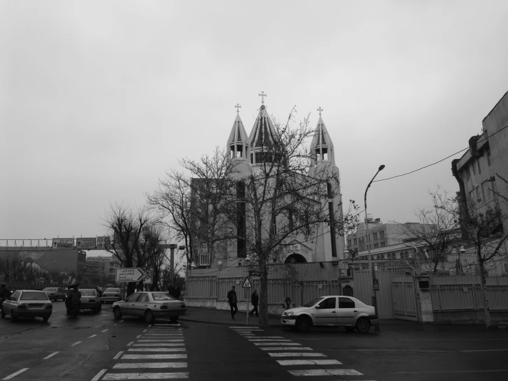 cars on a road next to a tall church