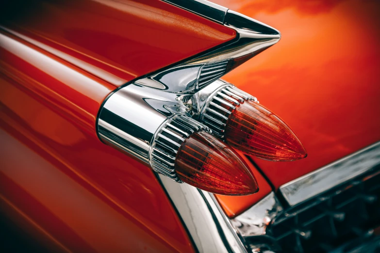 the tail lights of an old car with a red and gold color