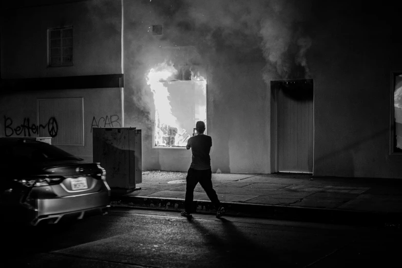 man standing next to parked cars in a dark street