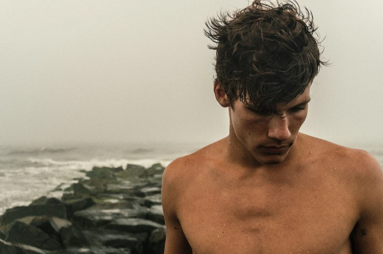 man wearing  standing next to ocean