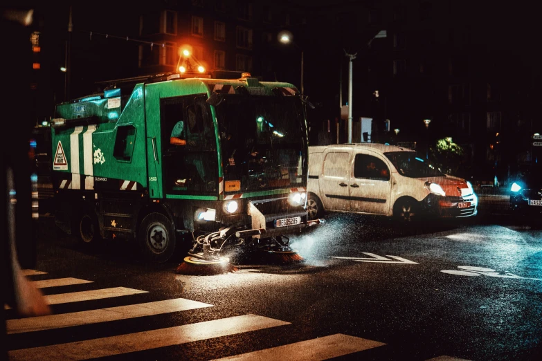 a green utility truck on the road in the rain