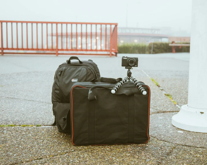 a bag is sitting on the ground and a suit case is laying on the ground