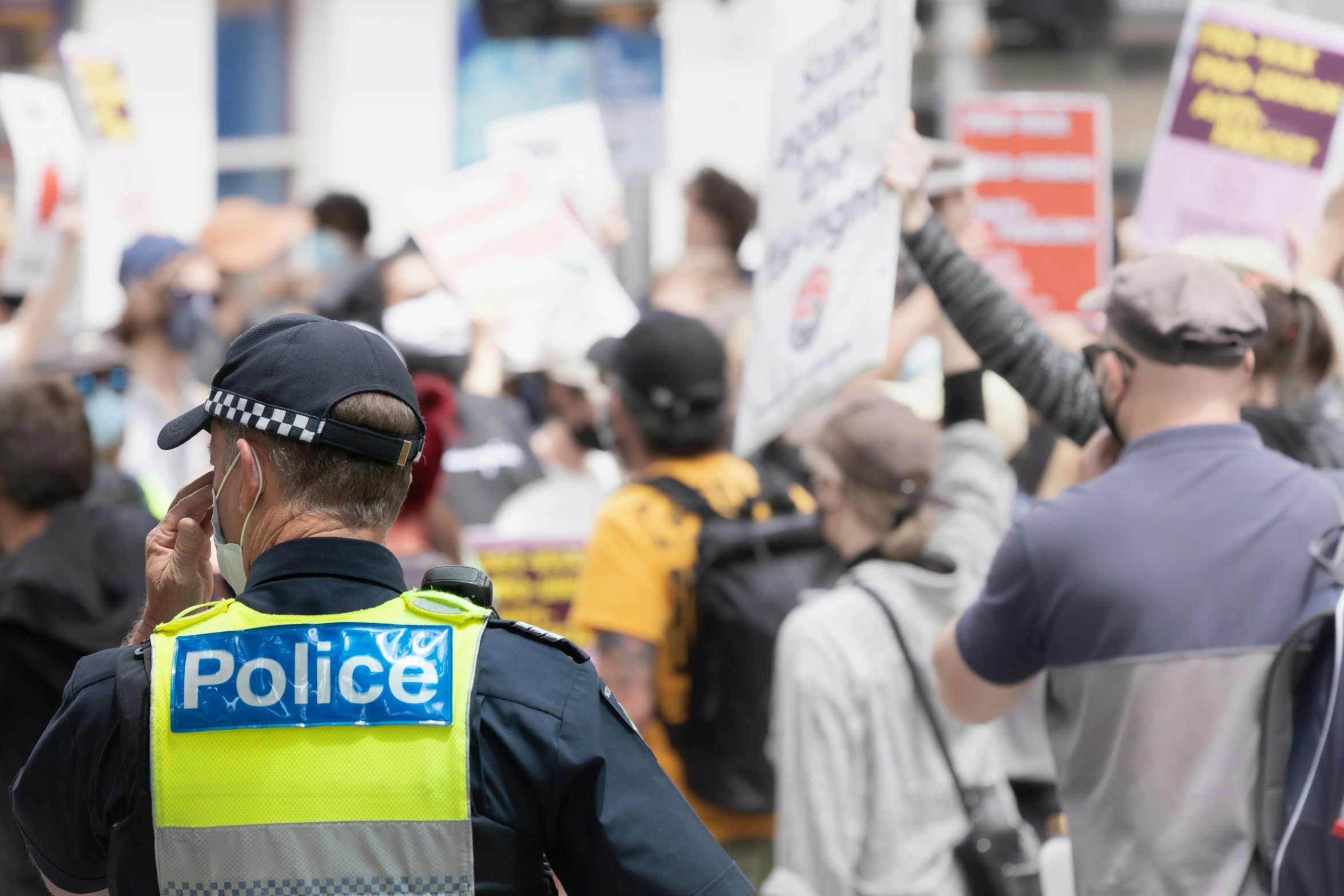 a police officer in the middle of a large group of protesters