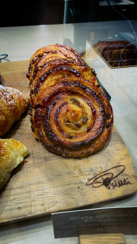 a pile of cinnamon rolls and pastry on top of a  board