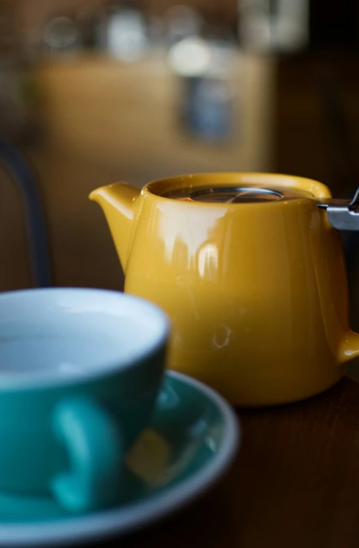 a blue tea cup and teapot sit on the table