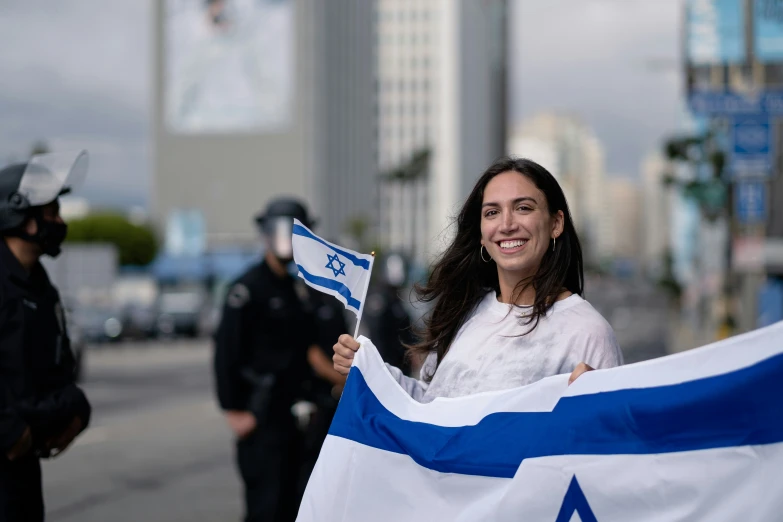 two people holding israeli and french flags on the street