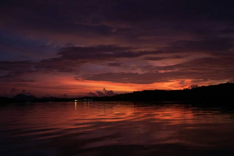 a lake is shown at sunset with clouds