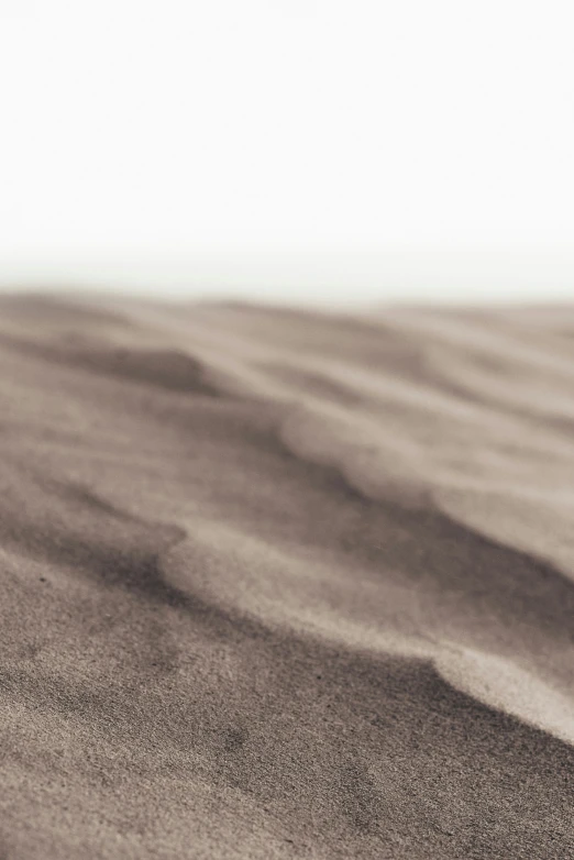 the sand is blowing gently while people are standing in the background