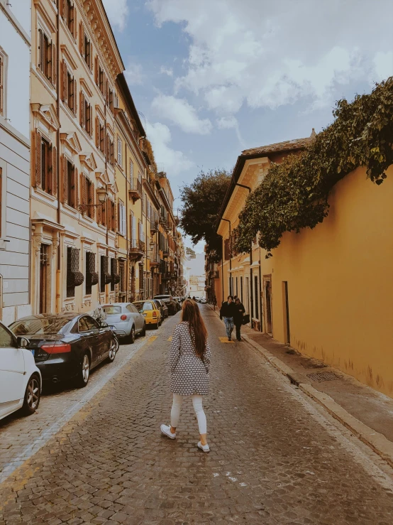 a person walking on a street in front of a building