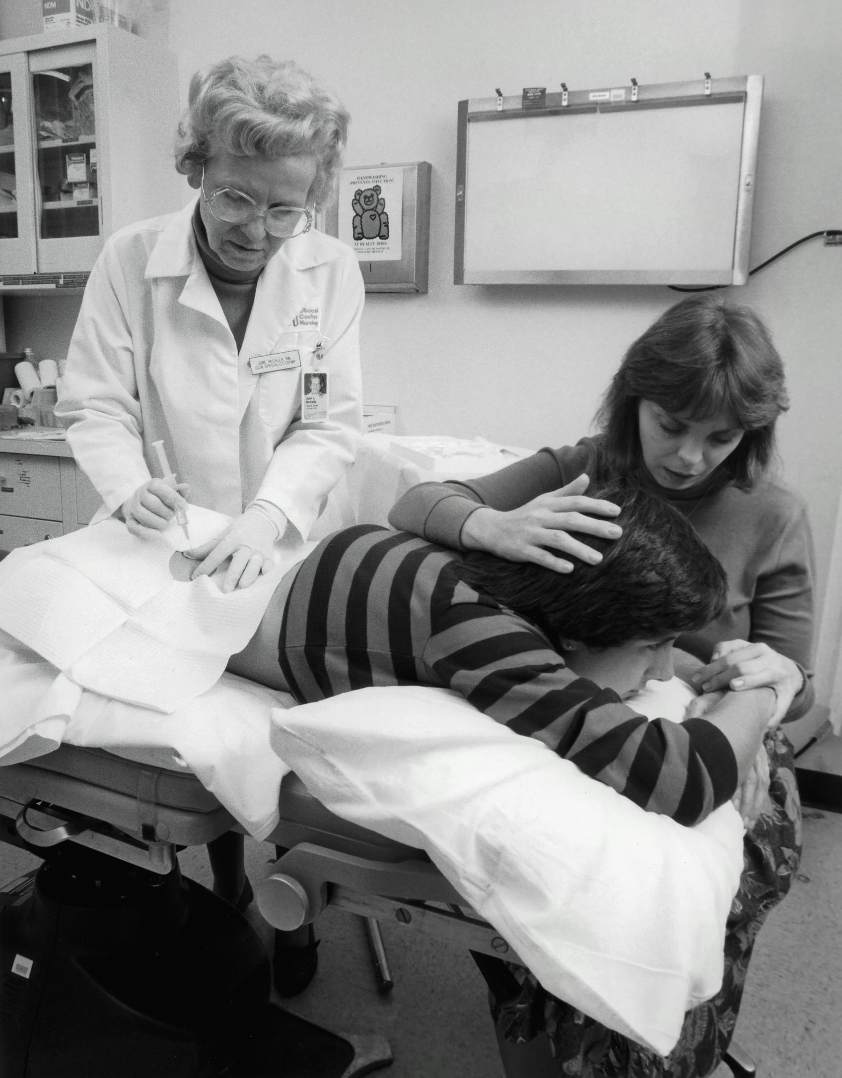 an old black and white po of a woman in a room with a woman in bed and a cat on her lap