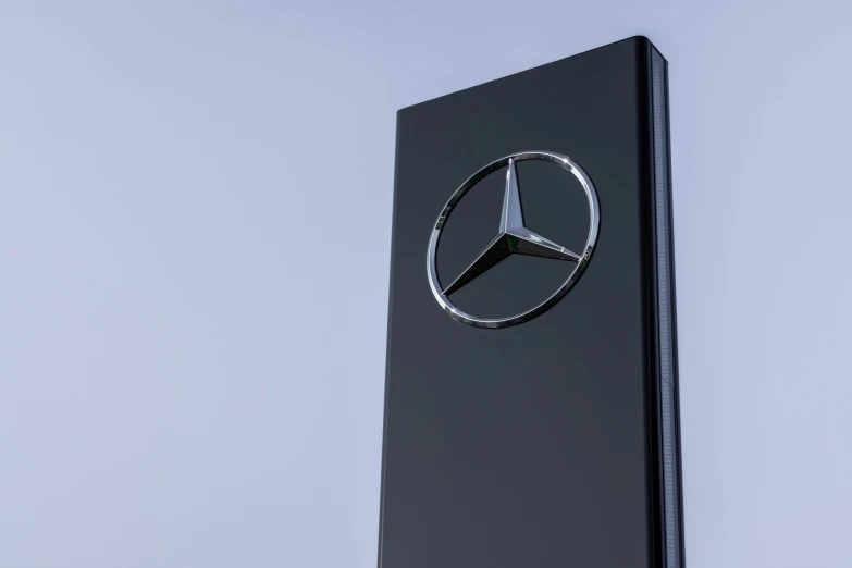 the mercedes logo is pictured on a black sign