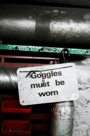 the sign is attached to a pipe in the background