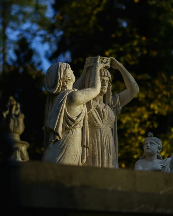 three statues in the shape of women are holding soing to their eyes