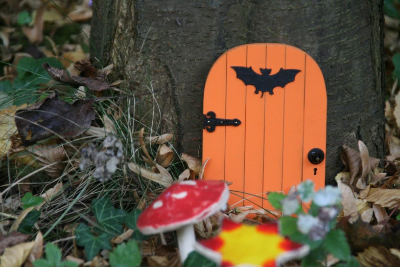 a fairy - themed door sits next to a mushroom house in the woods