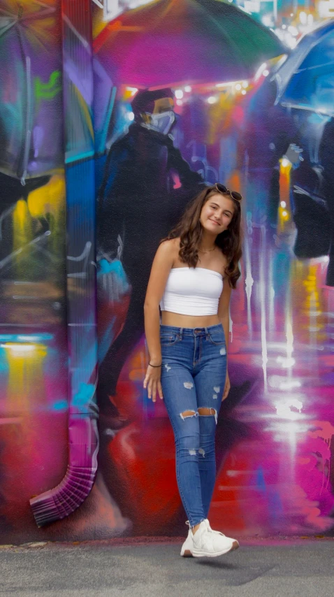 a woman is leaning against a colorful wall