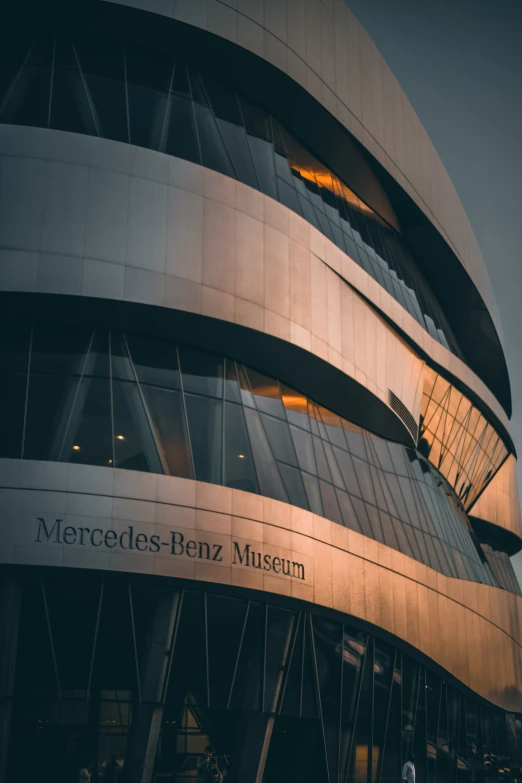 a large grey building with a curved glass and steel facade