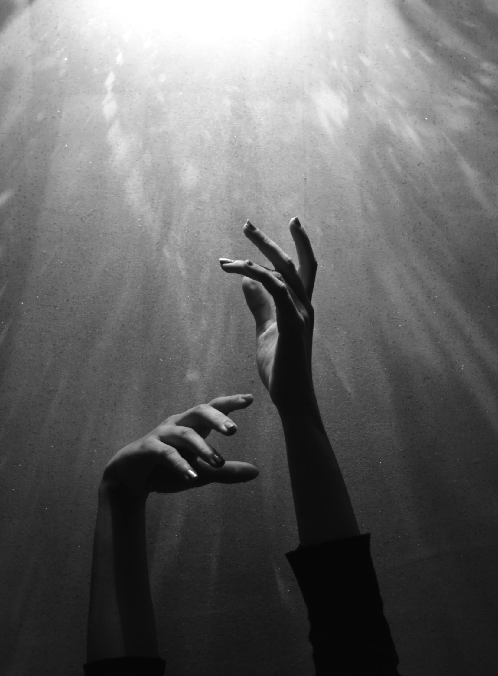 woman hand reaching out to the light from underwater