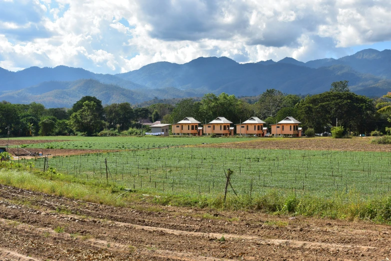 several house surrounded by mountains on a sunny day