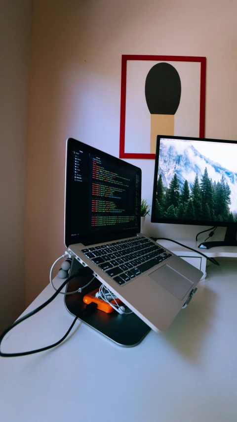 a desk that has two laptops, one on top of it