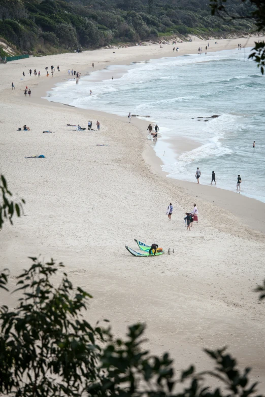 people walking on a beach near water and sand