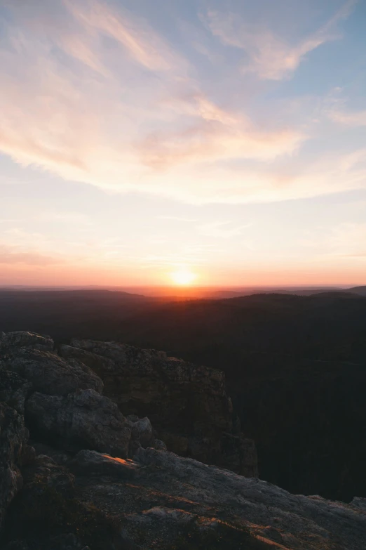 a sunset over the mountains and valley seen from above