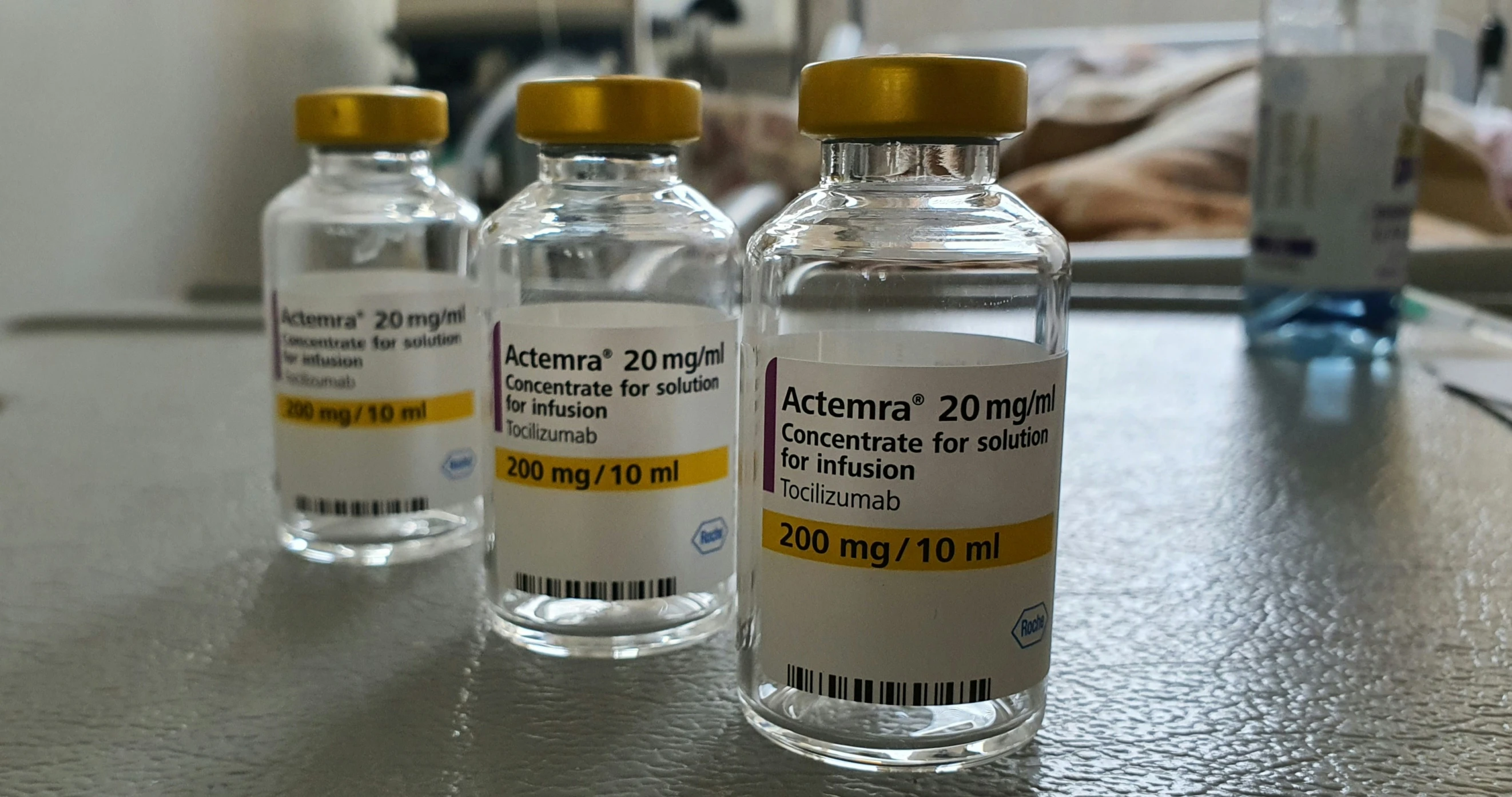 three medicine bottles on a counter, one with yellow caps