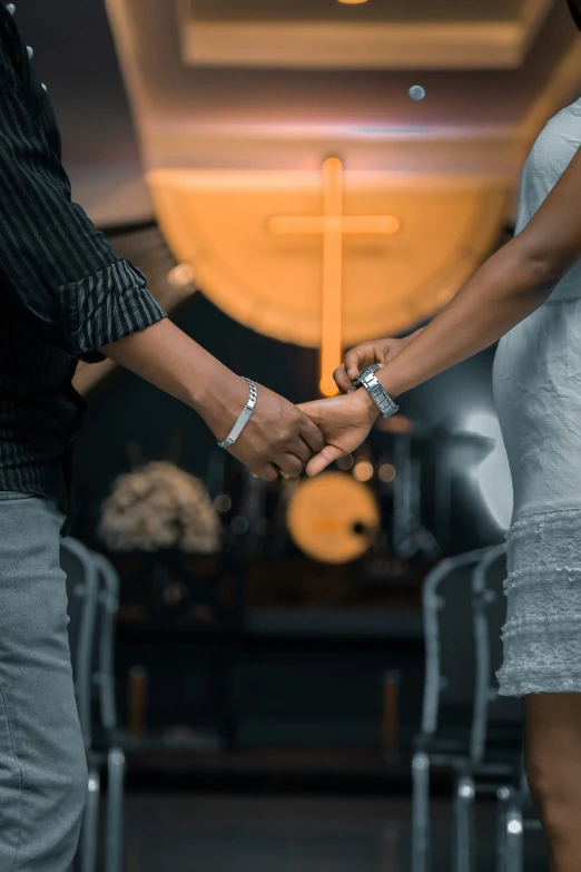 a couple holding hands while walking through a room