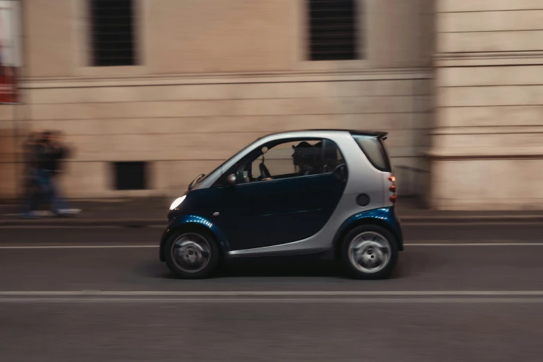 a small car is seen going down the road