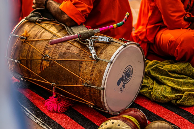 a group of men sit around a drum