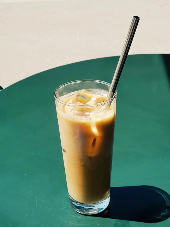 the beverage is sitting on top of the green table